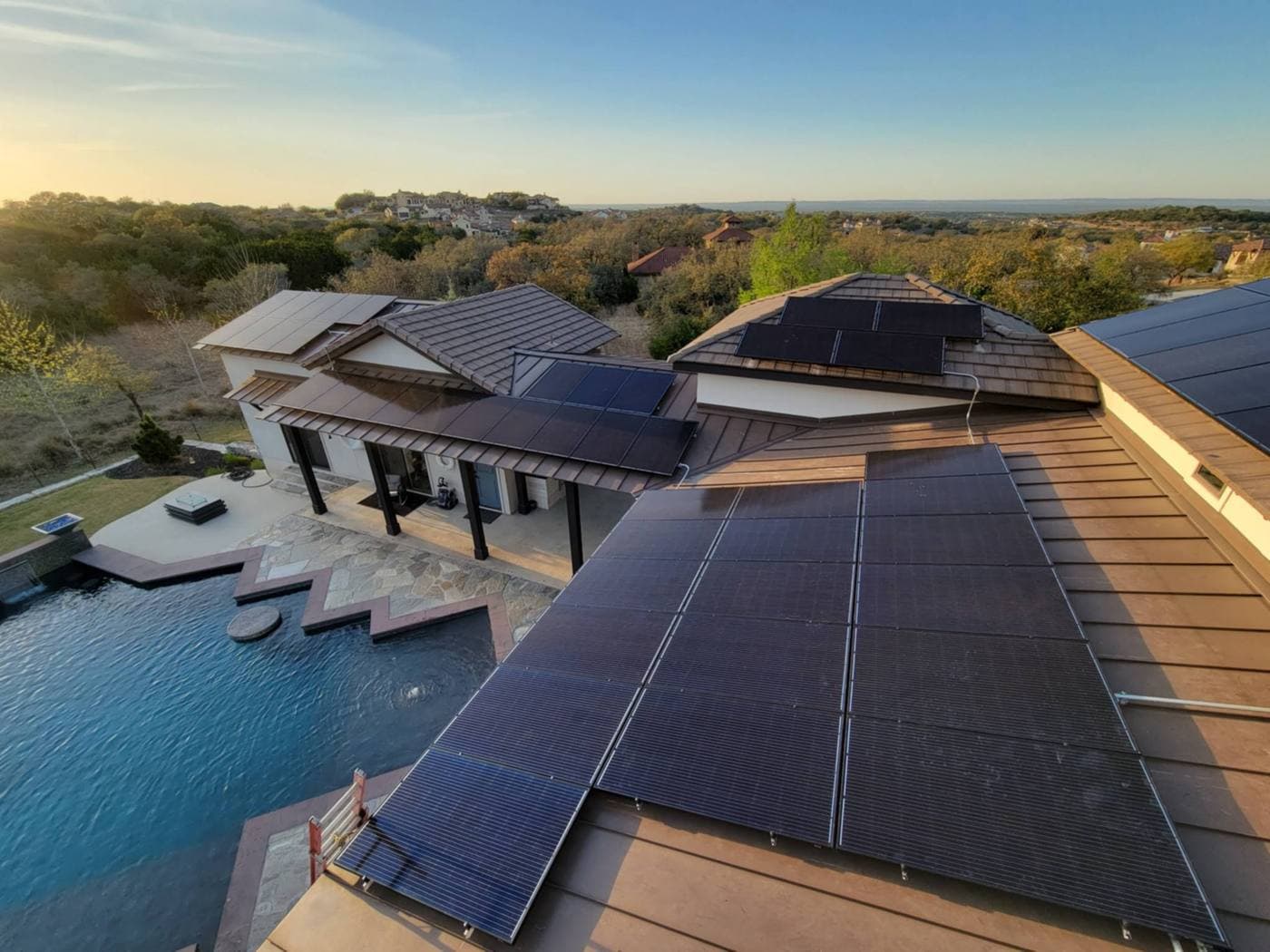 Aerial view of a tile roof solar array beside an infinity pool