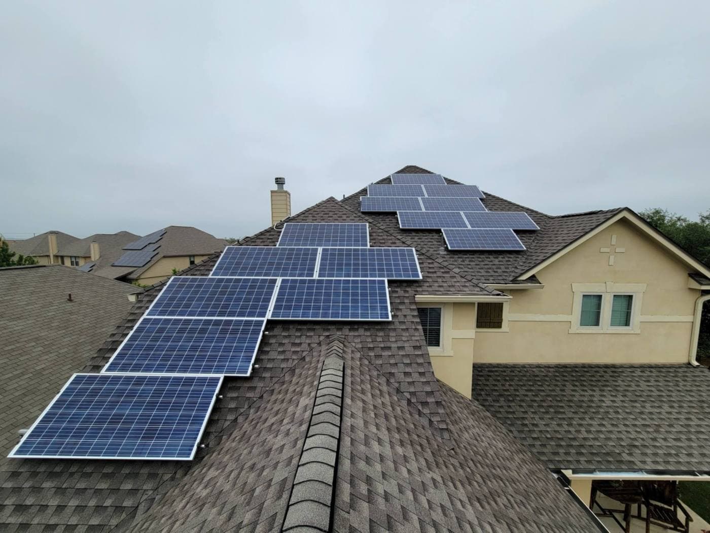 Aerial close-up of a full rooftop solar array on a stucco home
