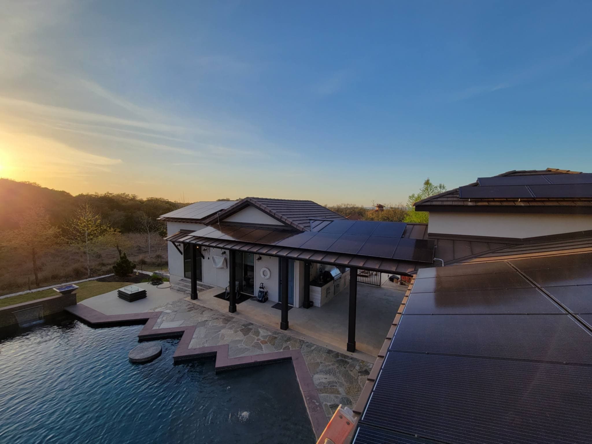 Solar panels on a San Antonio home at sunset, overlooking an infinity pool